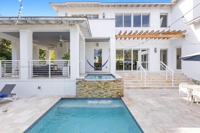 rear view of house featuring an in ground hot tub, ceiling fan, an outdoor pool, a patio, and stucco siding