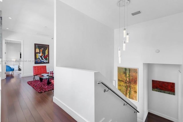 hall with recessed lighting, baseboards, an upstairs landing, wood finished floors, and visible vents