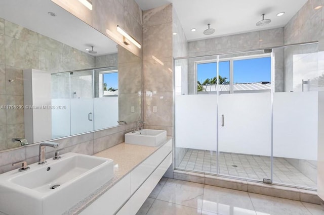 full bath with tile walls, a healthy amount of sunlight, and a sink
