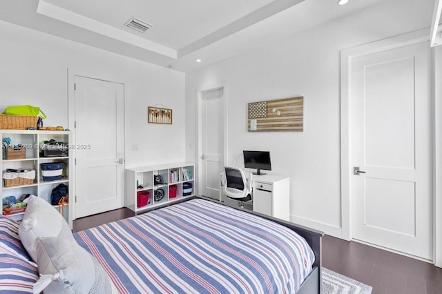 bedroom featuring a tray ceiling, dark wood-type flooring, recessed lighting, and visible vents
