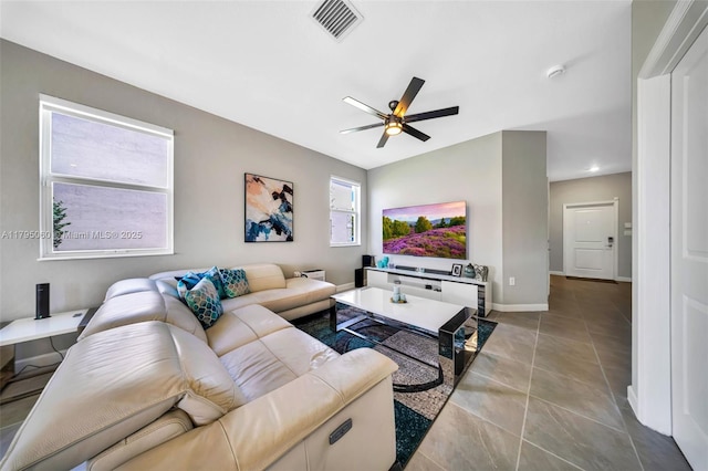 tiled living room with ceiling fan, visible vents, and baseboards