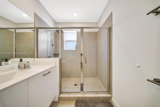full bath with vanity, baseboards, and a stall shower