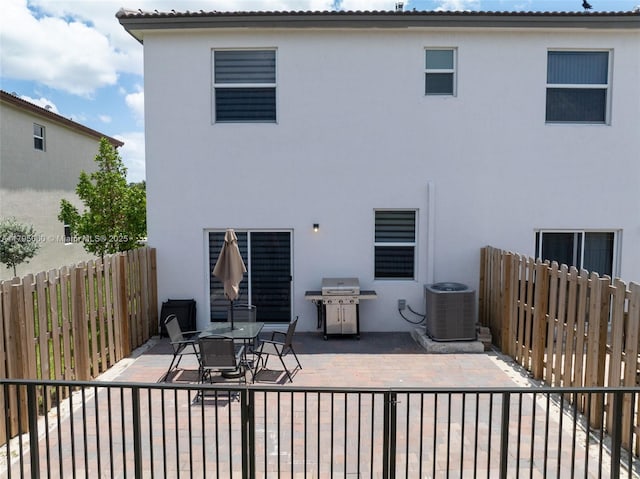 back of property featuring fence private yard, stucco siding, cooling unit, and a patio area