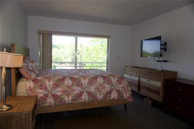 bedroom with access to outside and dark tile patterned flooring
