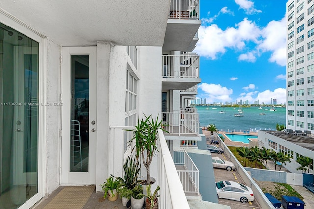 balcony with a water view and a view of city