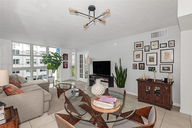 living room with french doors, visible vents, baseboards, a chandelier, and light tile patterned flooring