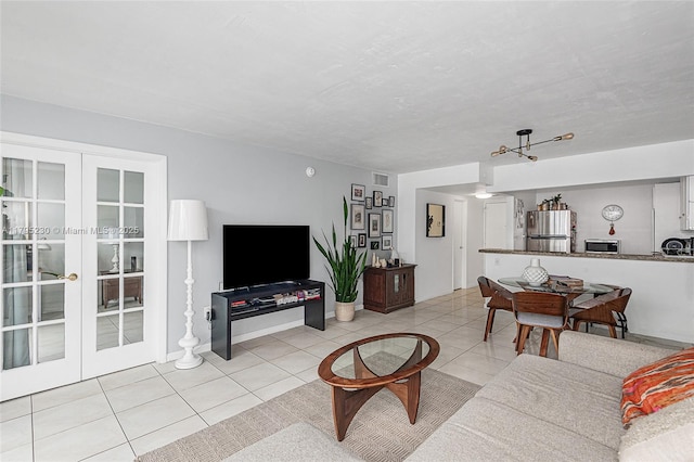 living room with french doors, light tile patterned floors, and visible vents
