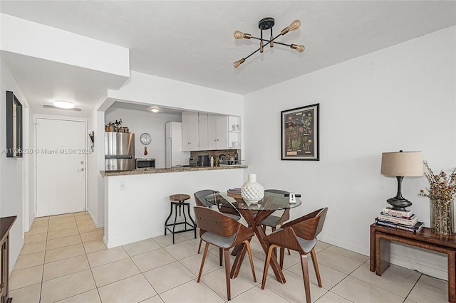 dining area featuring light tile patterned floors and a chandelier