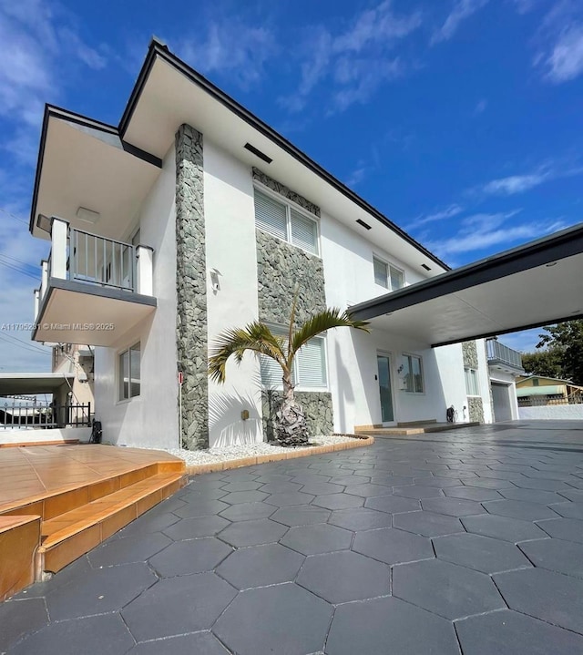 901 NW 22nd Pl, Miami, FL 33125 - exterior space featuring stucco siding, a balcony, and stone siding