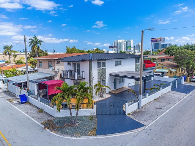901 NW 22nd Pl, Miami, FL 33125 - view of front of property with a fenced front yard, stucco siding, a gate, a balcony, and a city view
