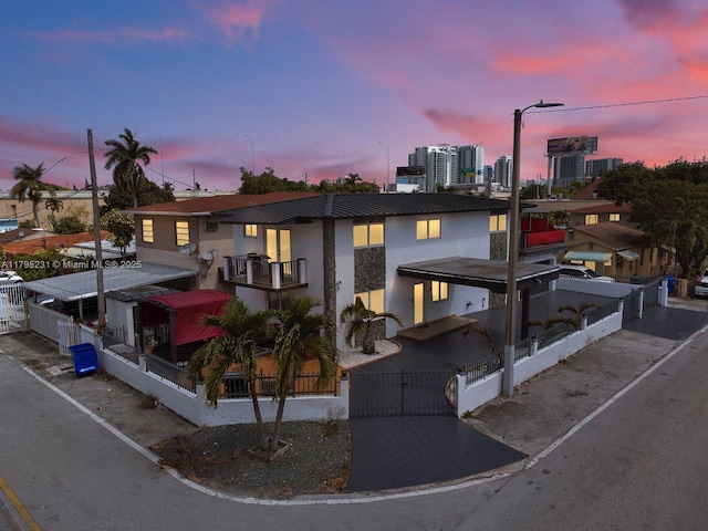 901 NW 22nd Pl, Miami, FL 33125 - view of front of property with a view of city, a fenced front yard, stucco siding, a gate, and a balcony