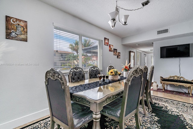 901 NW 22nd Pl, Miami, FL 33125 - dining room featuring baseboards, visible vents, a textured ceiling, and a notable chandelier