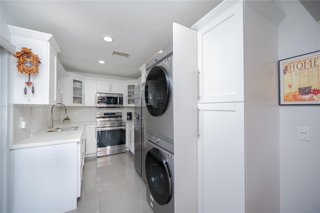 clothes washing area with visible vents, stacked washer and clothes dryer, recessed lighting, a sink, and light tile patterned floors