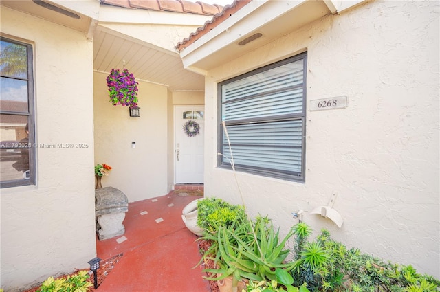 property entrance with a porch and stucco siding
