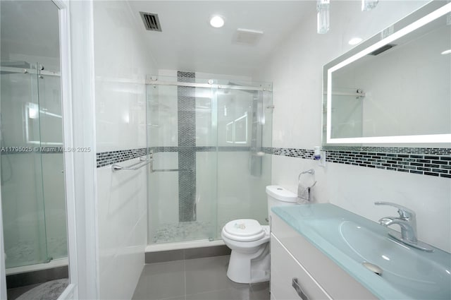 full bathroom featuring visible vents, tile patterned flooring, toilet, and a shower stall