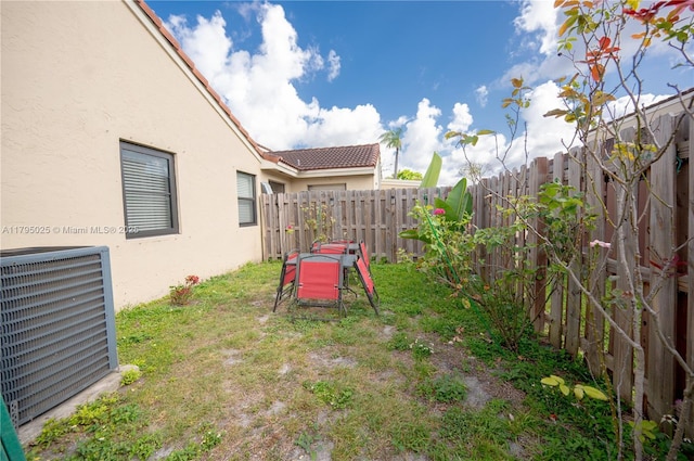 view of yard with central AC unit and a fenced backyard