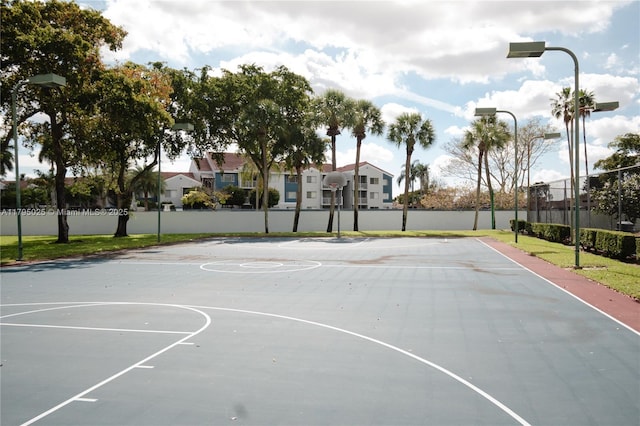 view of basketball court featuring community basketball court, fence, and a residential view