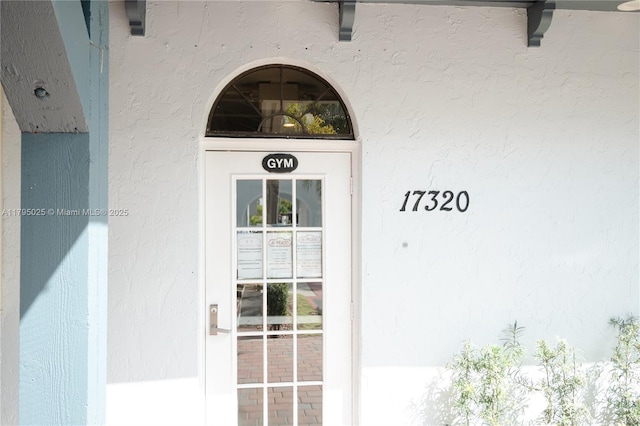 view of exterior entry with stucco siding