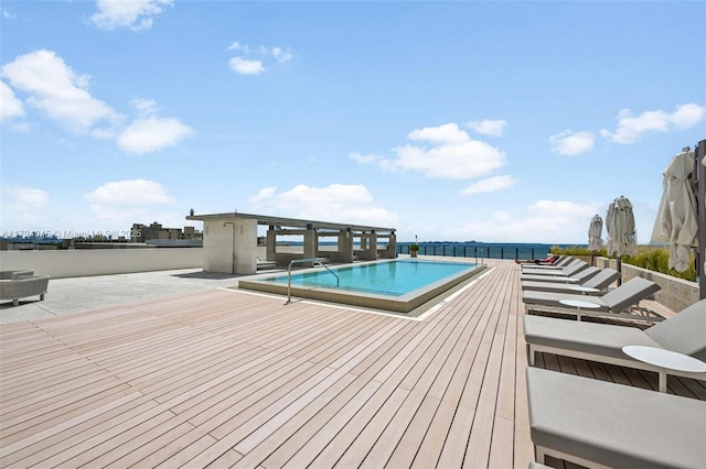 community pool with a patio area and a deck