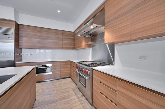 3581 E Glencoe St Unit 207, Miami, FL 33133 - kitchen with light countertops, wall chimney exhaust hood, modern cabinets, and high quality appliances