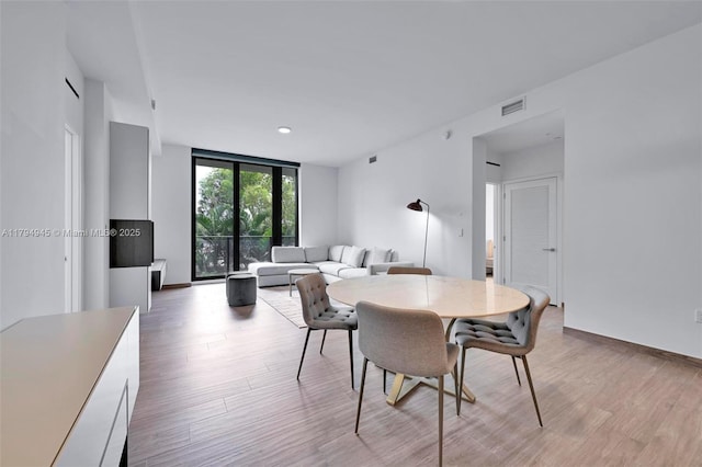 dining area featuring light wood-type flooring and visible vents