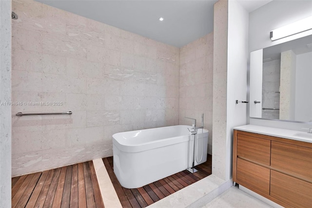 full bathroom featuring vanity, wood-type flooring, and a freestanding bath
