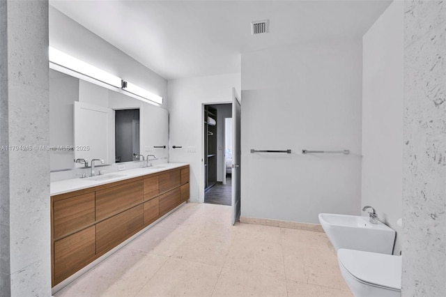 bathroom featuring toilet, visible vents, a bidet, and a sink