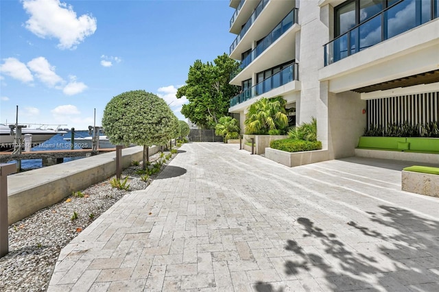 surrounding community with a water view, boat lift, and a dock