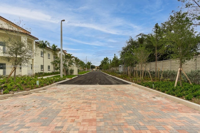 view of street with a residential view, curbs, and street lights