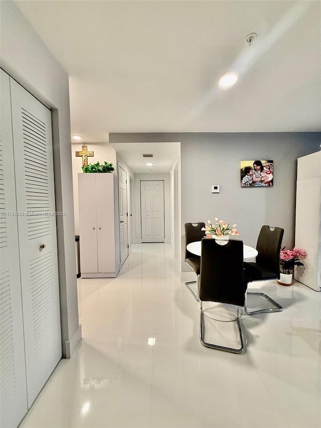 corridor with light tile patterned floors and baseboards