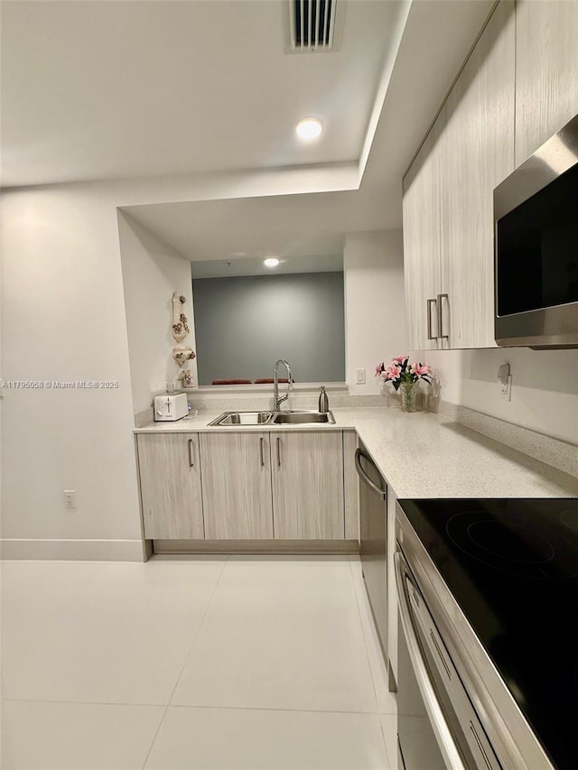kitchen featuring a sink, light brown cabinets, light countertops, stainless steel appliances, and visible vents