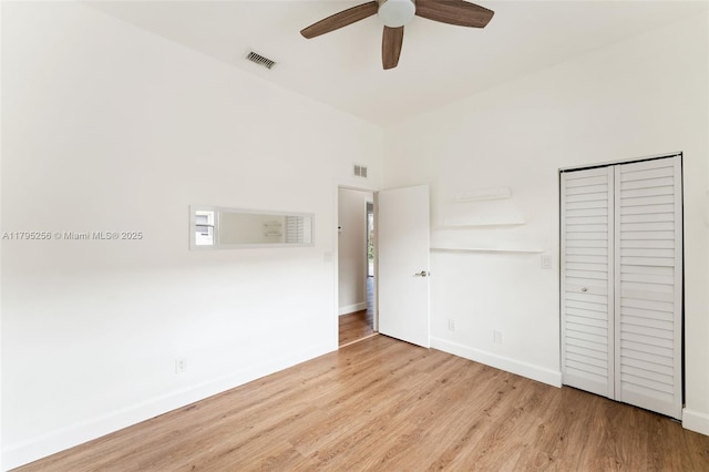 unfurnished bedroom with a ceiling fan, visible vents, wood finished floors, and baseboards