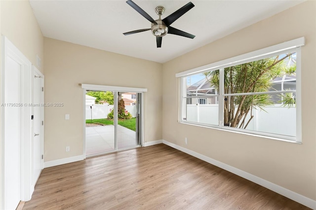 unfurnished room featuring light wood finished floors, baseboards, and a healthy amount of sunlight