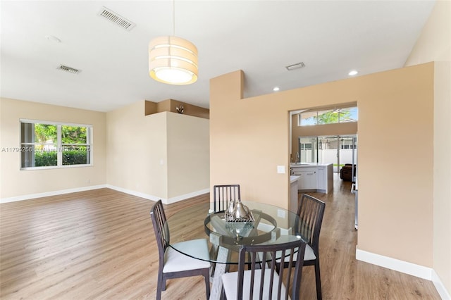 dining room featuring visible vents, wood finished floors, and baseboards