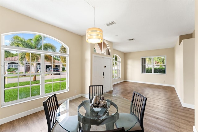 dining space featuring baseboards, visible vents, and wood finished floors