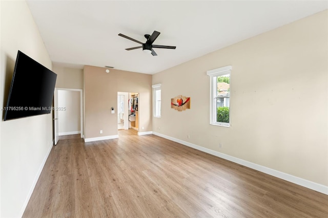 unfurnished living room featuring ceiling fan, light wood-style flooring, and baseboards