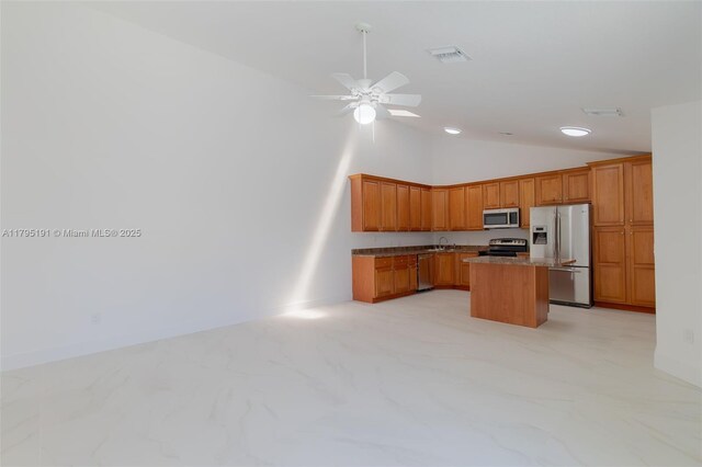5926 Golden Eagle Cir, Palm Beach Gardens, FL 33418 - kitchen with stainless steel appliances, vaulted ceiling, a kitchen island, ceiling fan, and brown cabinets