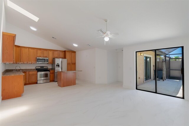 5926 Golden Eagle Cir, Palm Beach Gardens, FL 33418 - kitchen with stainless steel appliances, open floor plan, a sink, lofted ceiling, and a kitchen island