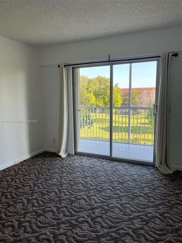 carpeted empty room featuring baseboards and a textured ceiling