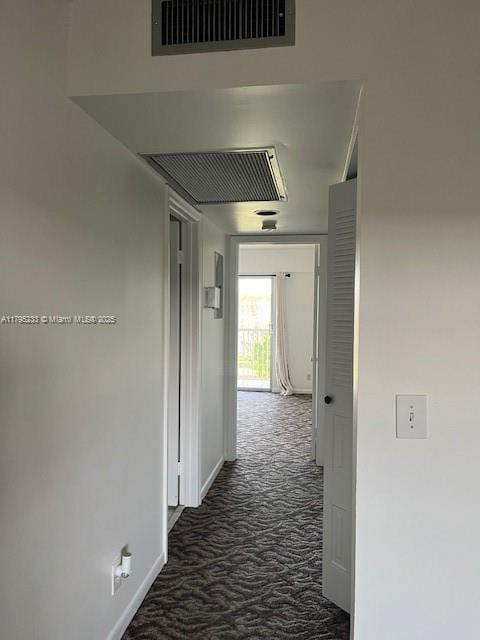 corridor featuring baseboards and visible vents