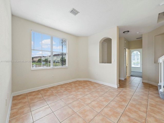 unfurnished room featuring light tile patterned floors, baseboards, and visible vents