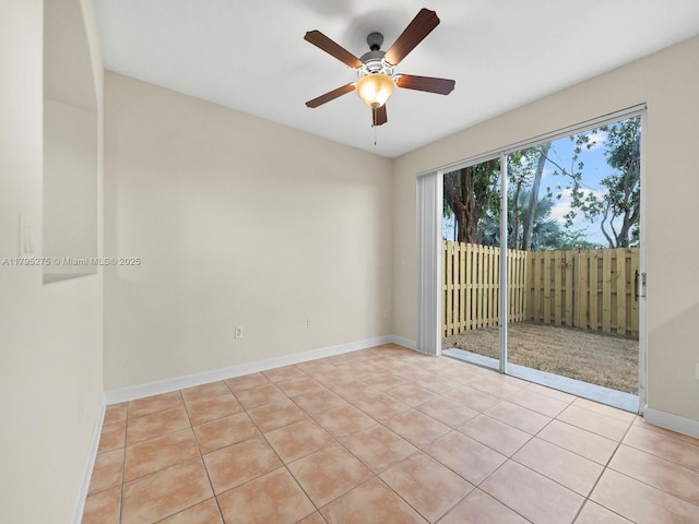 empty room featuring light tile patterned flooring, ceiling fan, and baseboards