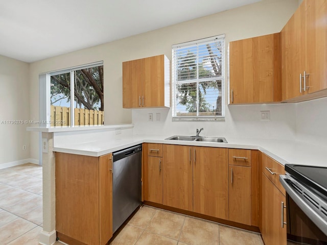 kitchen with stainless steel dishwasher, a sink, brown cabinetry, and a peninsula
