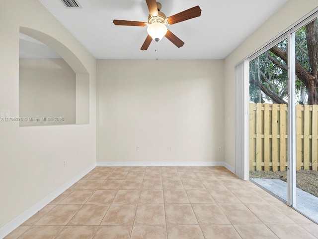unfurnished room featuring light tile patterned flooring, arched walkways, a ceiling fan, baseboards, and visible vents