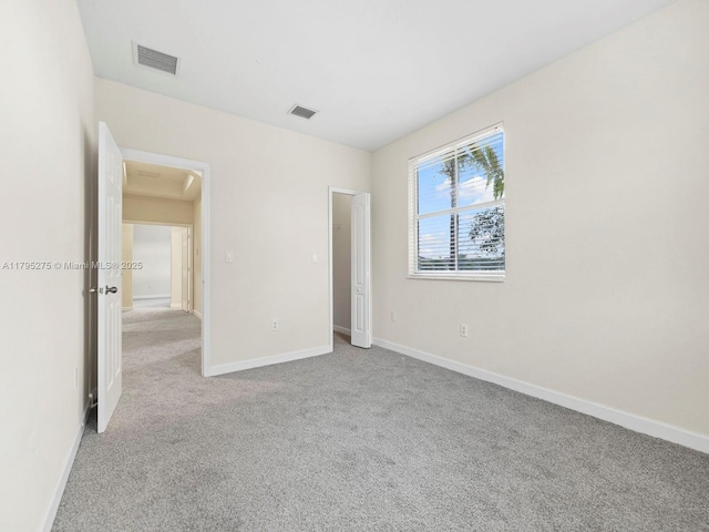 unfurnished bedroom with visible vents, carpet, and baseboards