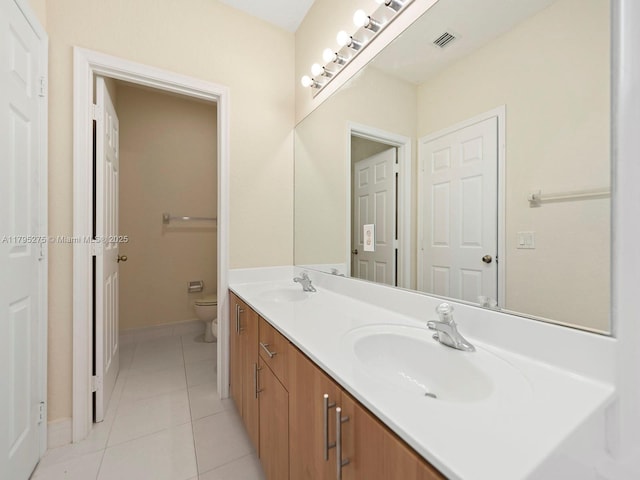 bathroom with toilet, visible vents, a sink, and tile patterned flooring