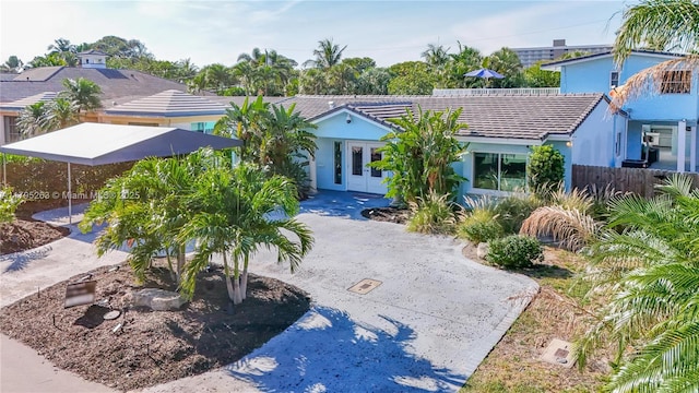 single story home with french doors, a tile roof, stucco siding, and fence
