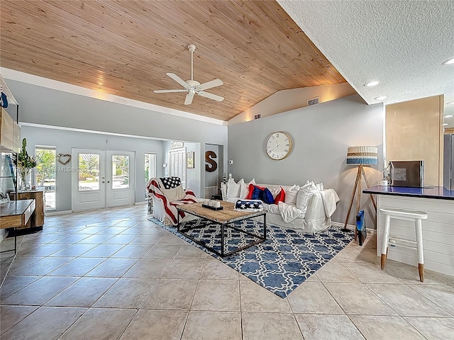 living area with lofted ceiling, wood ceiling, ceiling fan, tile patterned flooring, and baseboards