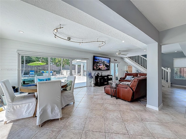 dining area with stairway, a ceiling fan, light tile patterned floors, a textured ceiling, and baseboards
