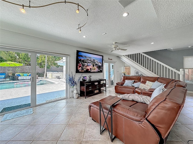 living area featuring french doors, stairs, a textured ceiling, ceiling fan, and light tile patterned flooring